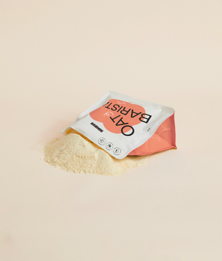 Oat Barista Powder lying on its side and spilling out